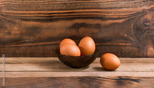 Brown eggs in a bowl on a wooden table, brown wooden background, copy space. Concept of cheap healthy source of protein.