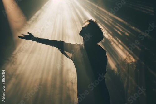A singer standing in front of a spotlight on a stage, silhouetted against the soft ethereal glow