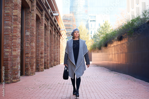 Confident woman walking in corridor, stylish urban attire photo