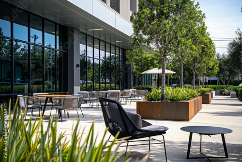 A patio with multiple tables and chairs set up outside a modern commercial building  ready for outdoor dining