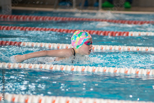Swimmer girl swims butterfly swimming style in the pool