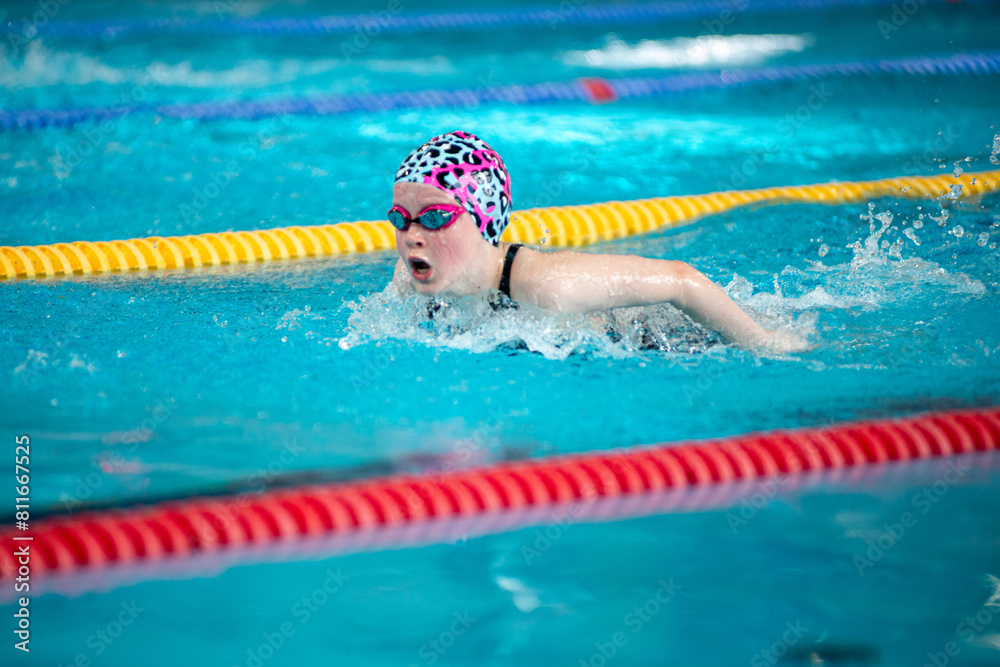 Swimmer girl swims butterfly swimming style in the pool