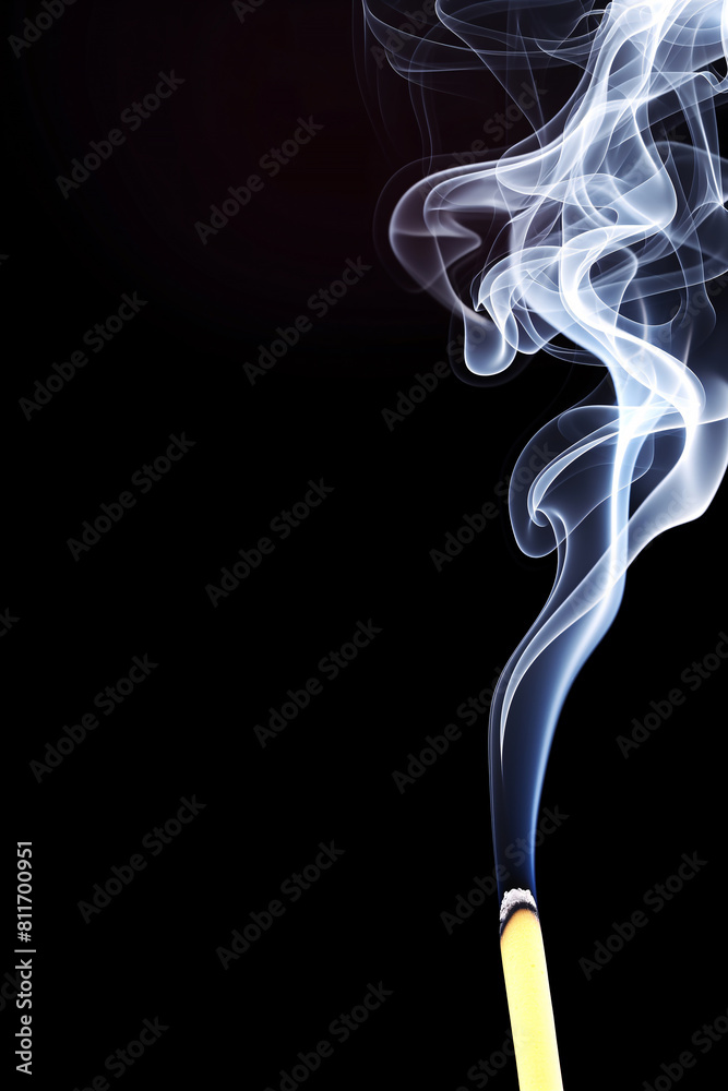 Elegant smoke plume rising from a lit incense stick in a dark setting Elegant smoke plume rising from a lit incense stick in a dark setting