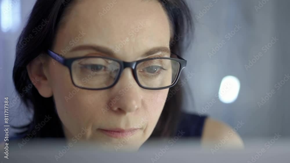 Woman with glasses engaged in reading or work, conveying concentration. Front view and close up portrait Woman with glasses engaged in reading or work, conveying concentration. Front view and close up portrait