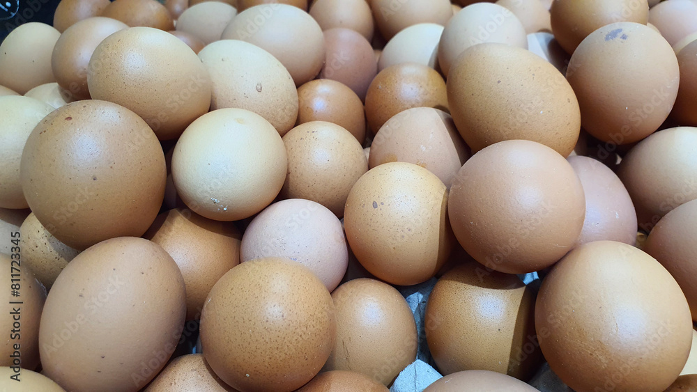 Close up of randomly stacked chicken eggs sold at the market as a background. Close up of randomly stacked chicken eggs sold at the market as a background.