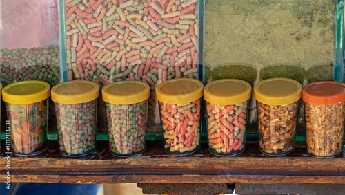 Fish food capsules in plastic boxes sold on a market stall