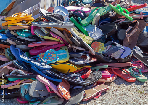Colorful flip flops sandals pile sold outside on a street