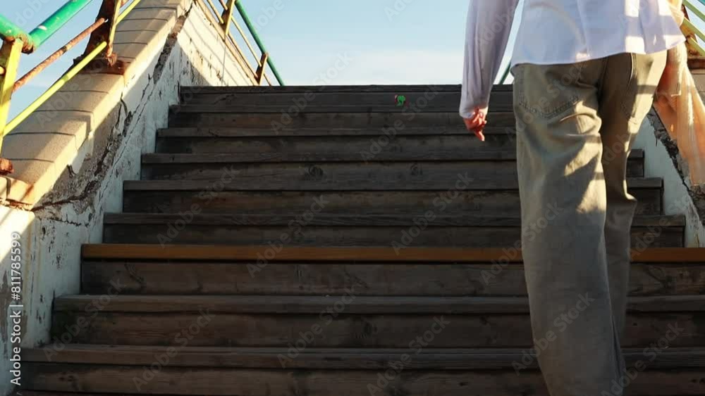 teenage girl in black sneakers and jeans climbs concrete steps of the stairs. Close view of legs teenage girl in black sneakers and jeans climbs concrete steps of the stairs. Close view of legs