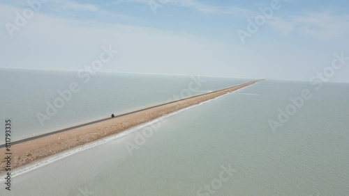 Aerial drone footag ef a bike riding in the middle of the ocean in road to heaven in gujrat photo
