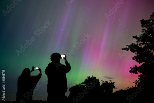 People taking pictures of the Northern Lights using their phone camera.