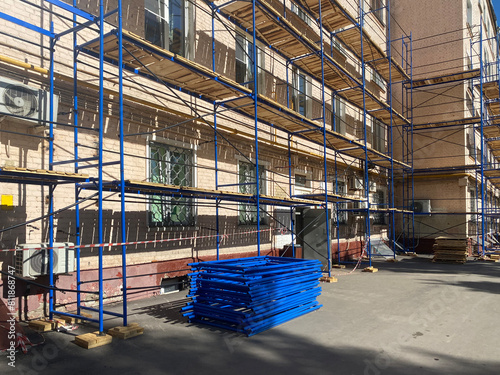 Temporary scaffolding frame construction assembled around buildings. Local home renovation concept. Mobile phone photo, not AI