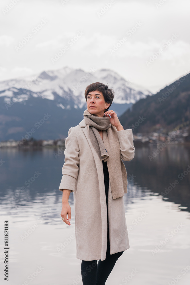 young elegant woman with short hair looks into the distance. mountains and a lake in the background on a cloudy autumn day. Remote work. Independent bussiness women young elegant woman with short hair looks into the distance. mountains and a lake in the background on a cloudy autumn day. Remote work. Independent bussiness women