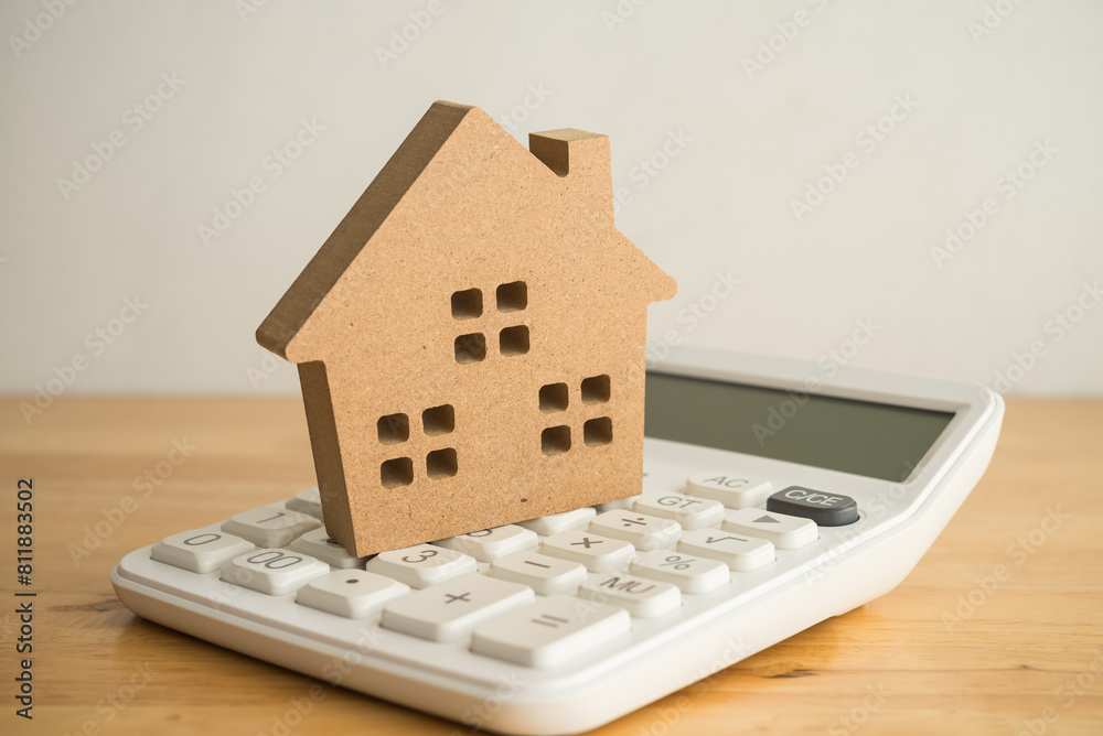 Wooden house on white calculator background copy space. Mortgage loan for buying home or real estate property, money saving plan, money risk management in financial banking concept. Wooden house on white calculator background copy space. Mortgage loan for buying home or real estate property, money saving plan, money risk management in financial banking concept.