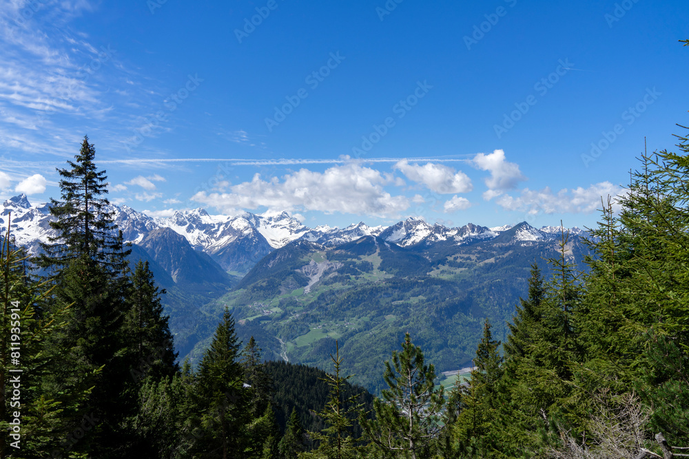 view from high up into a valley and the opposite landscape with mountains