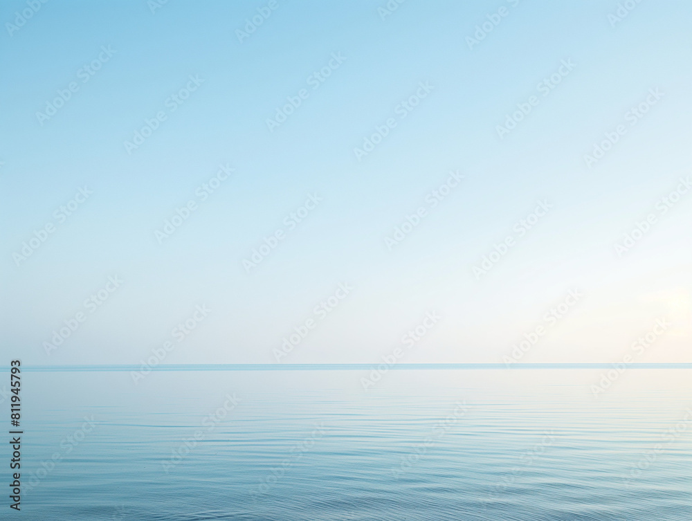 Fototapeta premium Tranquil sea under a clear sky at dawn, with gentle ripples and a soft gradient from blue to light orange.