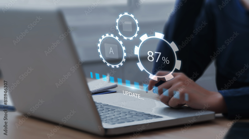Businessman updating computer system for device operating system to be up to date with new version. Graphics icon showing updating function screen loading on computer laptop. Businessman updating computer system for device operating system to be up to date with new version. Graphics icon showing updating function screen loading on computer laptop.