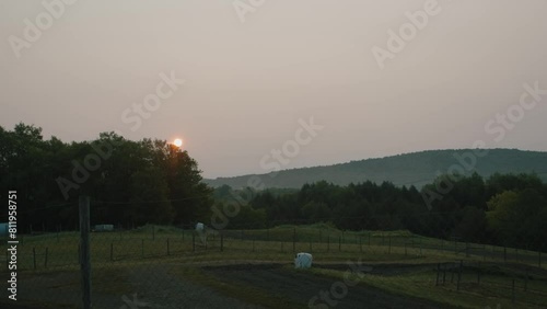 Sunrise over the trees on a farm