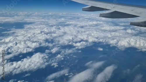 The view from the window of an air plane to the clouds, blue sunny sky.