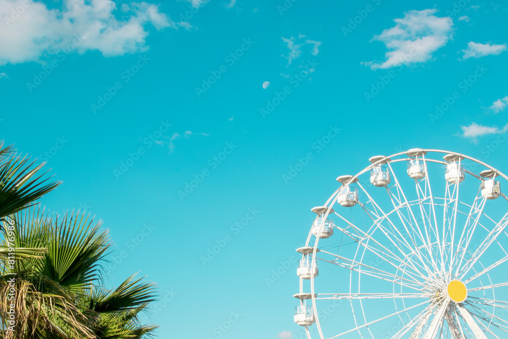 Fototapeta premium The white Ferris wheel against the blue sky. Happy feelings of a summer holiday