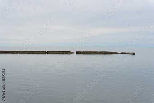 tranquil lake and old cement break water on an overcast day