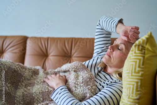 Economically Inactive Woman Suffering With Long Term Illness On Sofa At Home