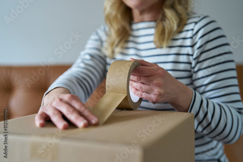 Woman Wrapping Parcel Using Green Environmentally Friendly Paper Or Plastic Free Sticky Tape