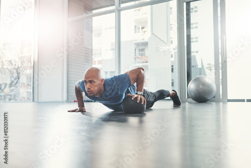 Man, push up and medicine ball in gym for fitness, health and wellness, athlete and workout. Exercise, strong and bodybuilder in sport centre for body care, performance and endurance training photo