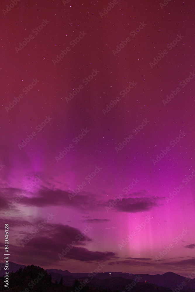 Beautiful violet pink red aurora borealis the northern lights over the horizon in Slovenia.