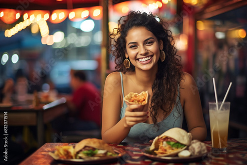 Happy Mexican woman eating tacos photo