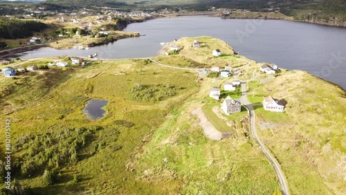 Aerial fly down Newfoundland village with peninsula and small homes overlooking Atlantic Canada.
 photo