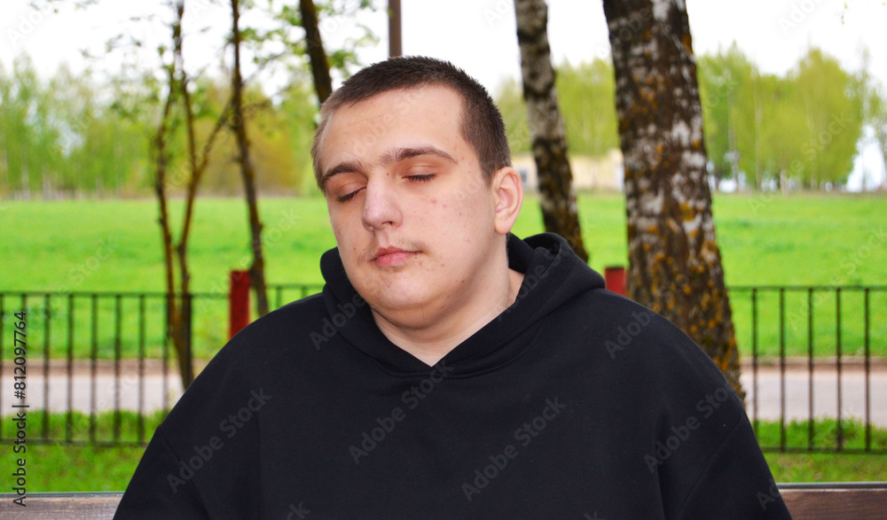 Autistic guy relaxing on a walk in the park with his eyes closed Autistic guy relaxing on a walk in the park with his eyes closed