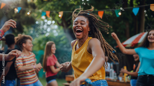 Teenagers playing music and dancing together at a backyard barbecue, their energy and enthusiasm evident in their lively movements. Dynamic and dramatic composition, with copy spac © Лариса Лазебная