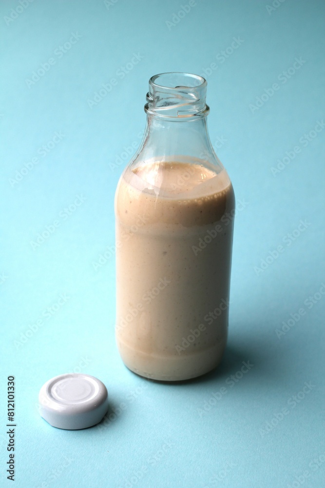 Yogurt in a glass bottle. Milkshake on a blue background. Place for inscription. Yogurt in a glass bottle. Advertising of healthy food. Low-calorie snack. Organic drink Yogurt in a glass bottle. Milkshake on a blue background. Place for inscription. Yogurt in a glass bottle. Advertising of healthy food. Low-calorie snack. Organic drink