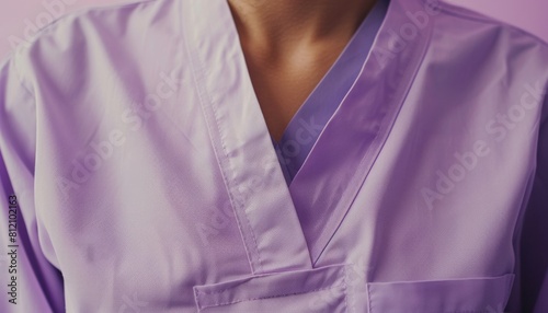 Closeup of a patients torso in a light purple hospital gown, isolated against a gentle, neutral background for a soothing effect © kitidach