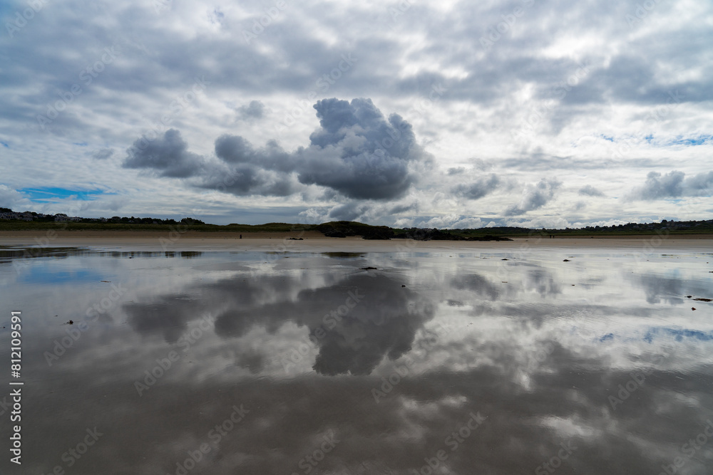 Obraz premium Reflets de gros nuages gris menaçants sur le sable mouillé d'une plage de la presqu'île de Crozon, une atmosphère saisissante et chargée d'émotion.