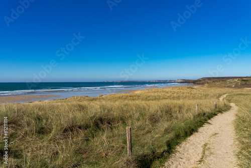 Le sentier c  tier serpente le long des dunes et des hautes herbes  offrant une vue   tendue sur la mer d Iroise et les falaises au loin  un spectacle naturel sur la presqu   le de Crozon