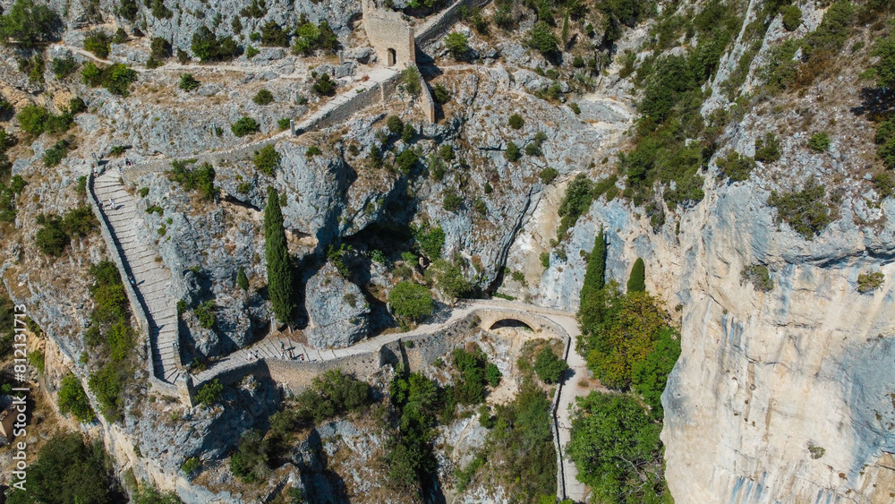Obraz premium small church perched on the mountain reachable via a long and winding staircase. at the foot of the mountain there is a small characteristic town. the church is isolated from everything in the nature