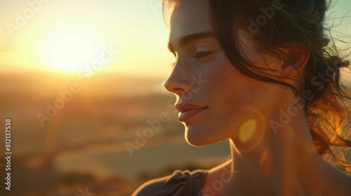 A happy woman, standing on top of a mountain at sunset with her eyes closed, feeling the heat and enjoying the stunning natural landscape and sky AIG50 © Summit Art Creations