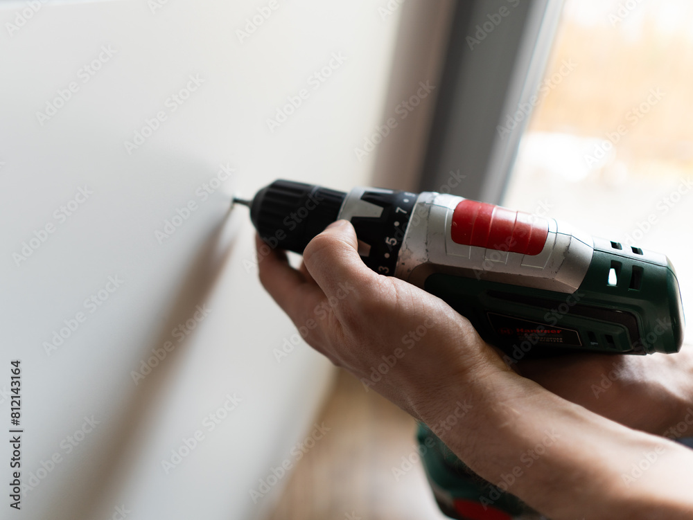 Fototapeta premium Furniture Assembly Manual. Workman Reading Instruction Installing Cabinet Making House Renovation Indoors.