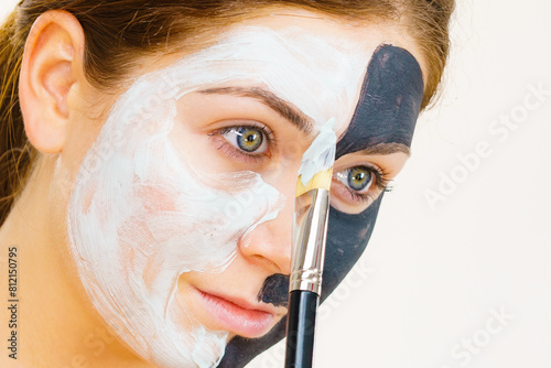 Girl black mask on half face apply white mud photo