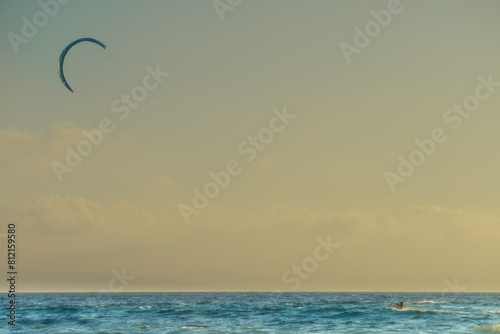 Kite surfer riding waves. Kiteboarding sport.