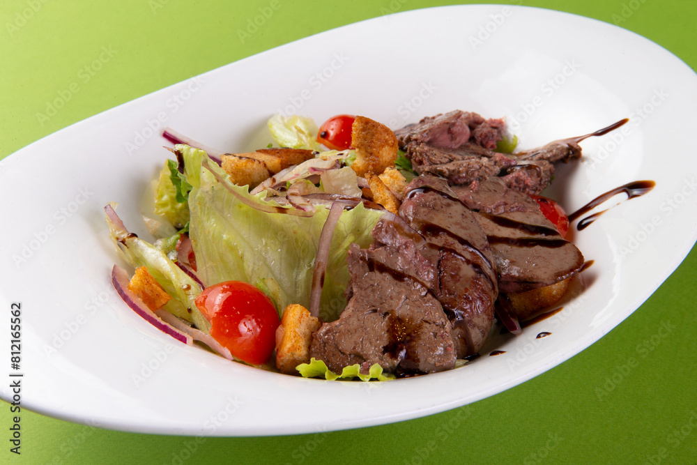 Salad with fried liver on a green background. Salad with fried liver on a green background.