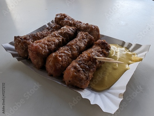 Obraz na płótnie Mici cu mustar and a toothpick on a paper plate. Traditional romanian fast food. w salonie