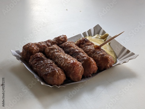 Obraz na płótnie Mici cu mustar and a toothpick on a paper plate. Traditional romanian fast food. w salonie
