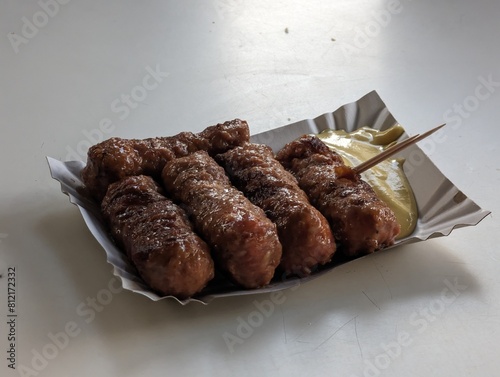 Obraz na płótnie Mici cu mustar and a toothpick on a paper plate. Traditional romanian fast food. w salonie