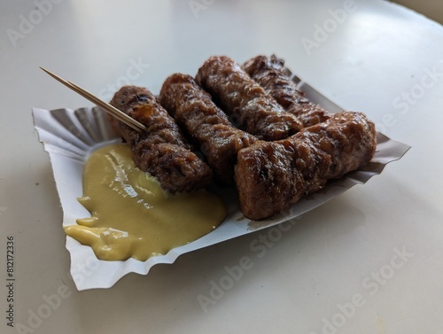 Obraz na płótnie Mici cu mustar and a toothpick on a paper plate. Traditional romanian fast food. w salonie