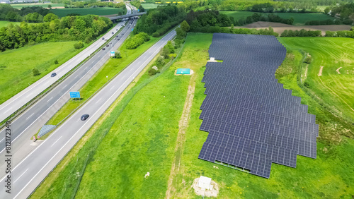 Drone flight on a German highway with lots of traffic and large solar panels next to the road. © Michael