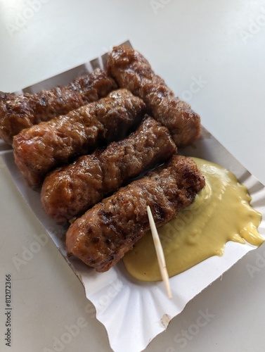 Obraz na płótnie Mici cu mustar and a toothpick on a paper plate. Traditional romanian fast food. w salonie