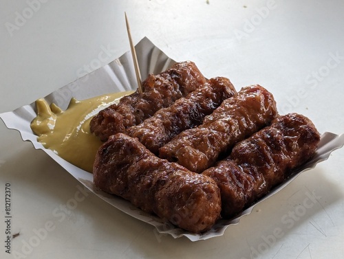 Obraz na płótnie Mici cu mustar and a toothpick on a paper plate. Traditional romanian fast food. w salonie