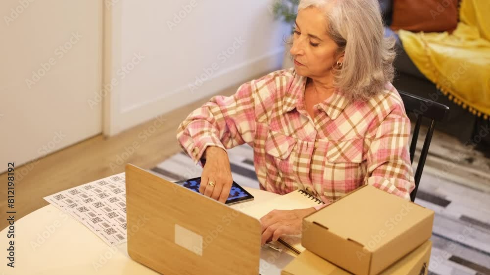 4k video Senior woman preparing shipments with QR codes and recyclable material. Concept: Work, business 4k video Senior woman preparing shipments with QR codes and recyclable material. Concept: Work, business